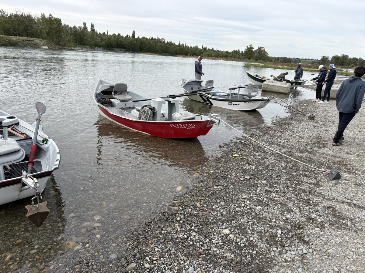 Drift boats at a Bow River launch point ready for guided fishing trips near Calgary