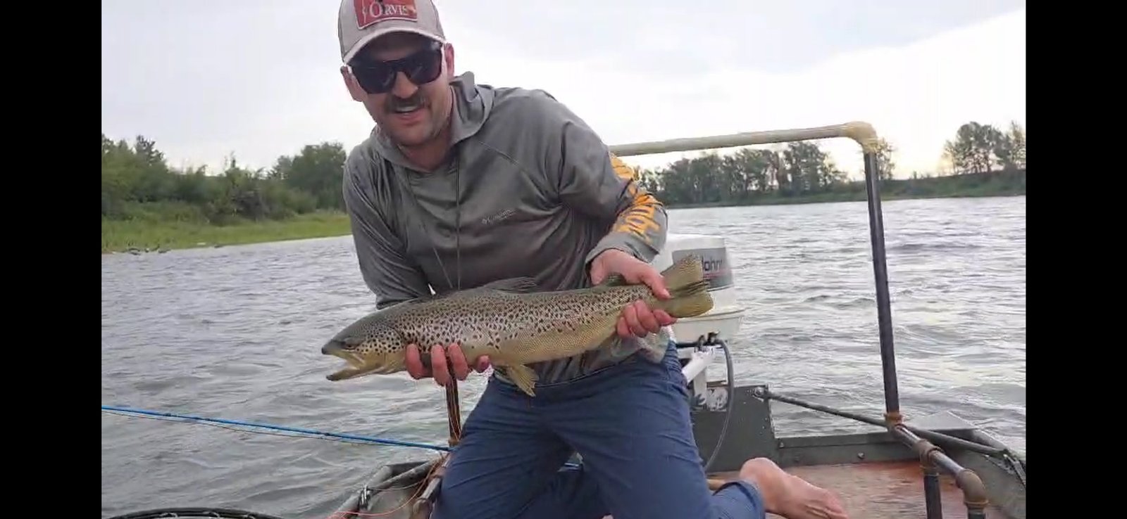 Happy client with trophy brown trout - King Trout Outfitters Calgary fly fishing success